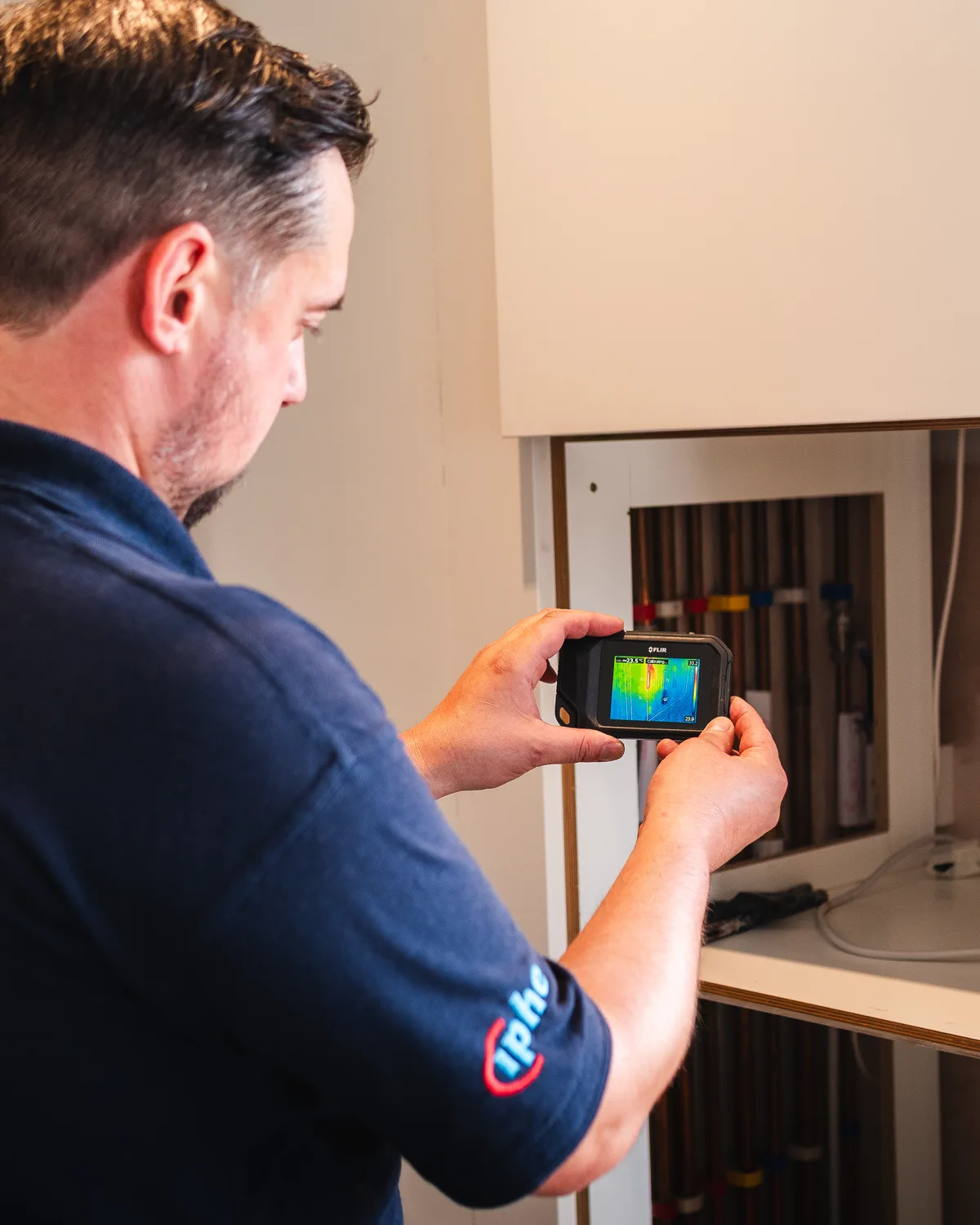ADI engineer surveying concealed pipework with a thermal camera